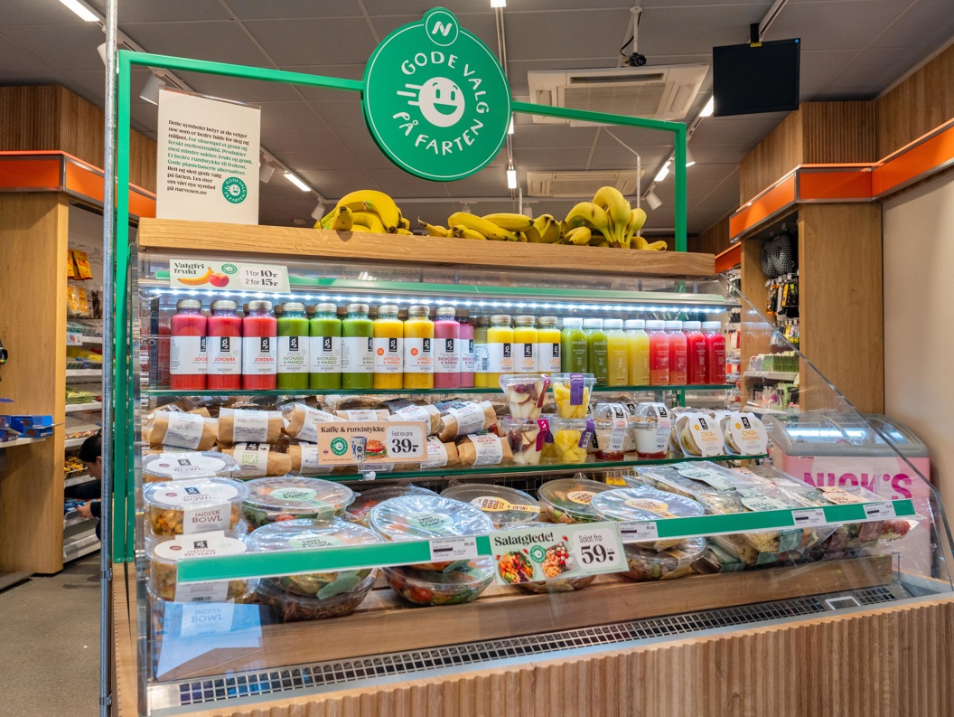 Moderne WHSmith-kiosk på en flyplass som tilbyr dagligvarer, snacks og drikkevarer under livlig belysning