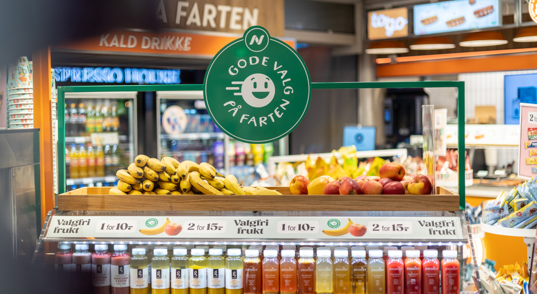 Moderne Narvesen-kiosk på en flyplass som tilbyr nødvendighetsartikler, snacks og drikkevarer under levende belysning