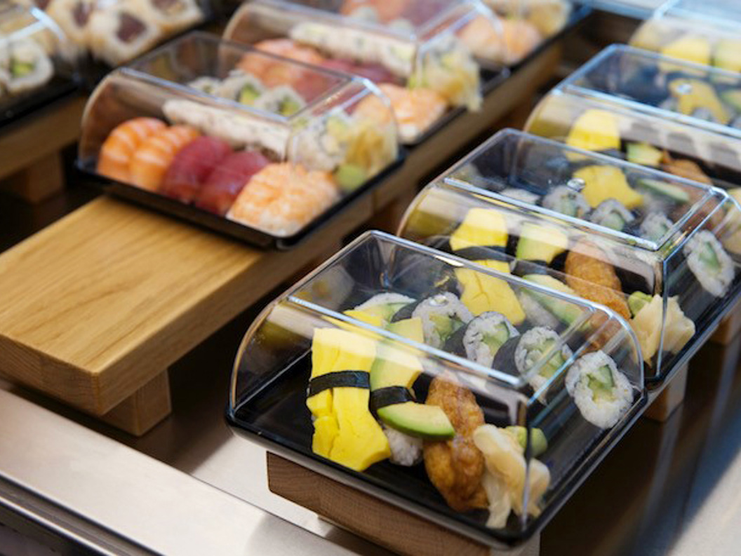 Sushi i plastboksar på utstillingsbord, med variasjonar av nigiri og maki med fersk laks, tunfisk og egg