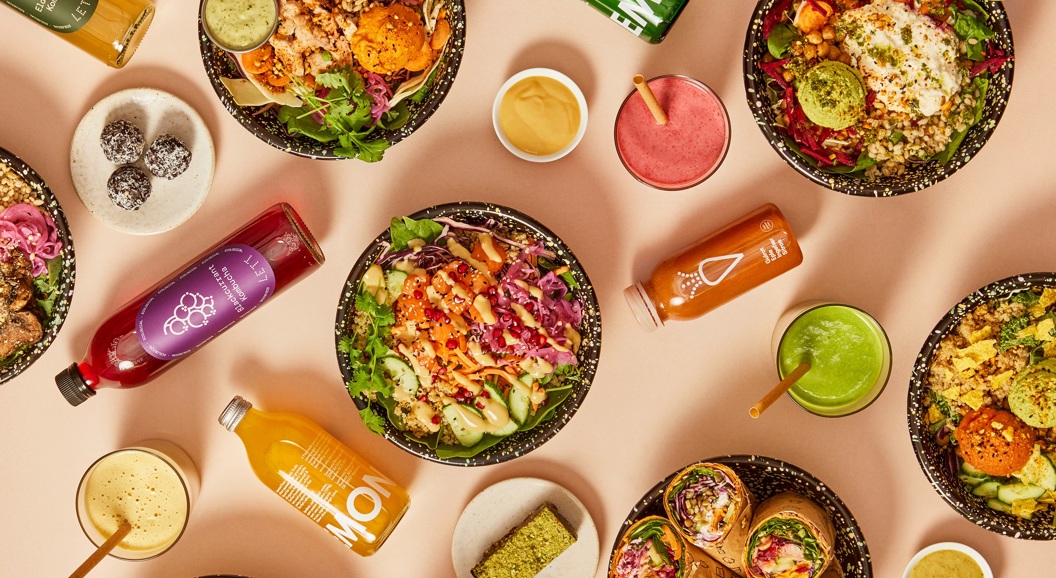 Fargerik mat: ulike salatbollar, juiceflasker og smoothie i ei estetisk oppstilling på eit bord