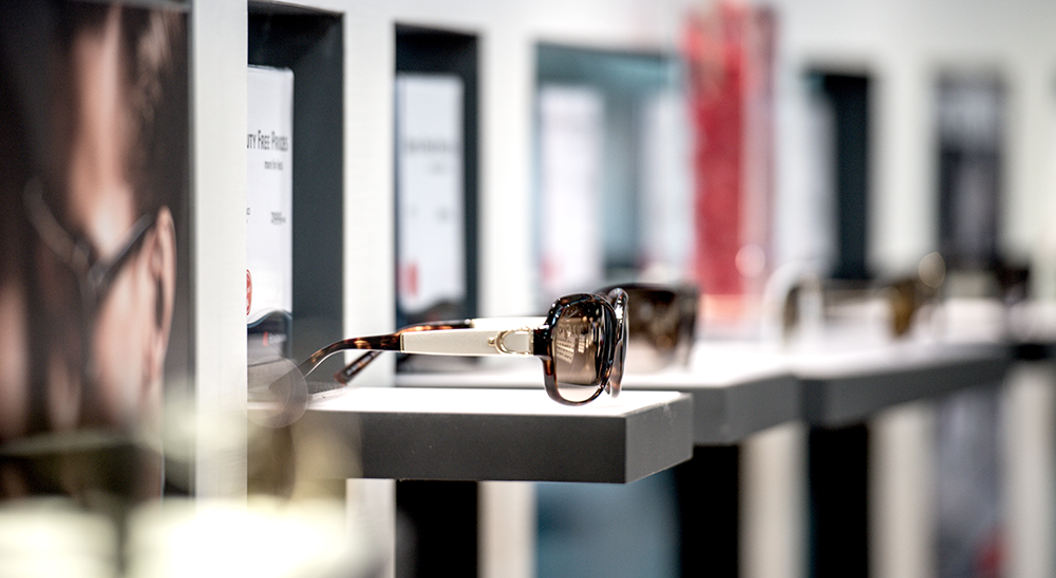 Sunglasses displayed on sleek shelves in a modern eyewear store, highlighting a stylish and contemporary shopping environment