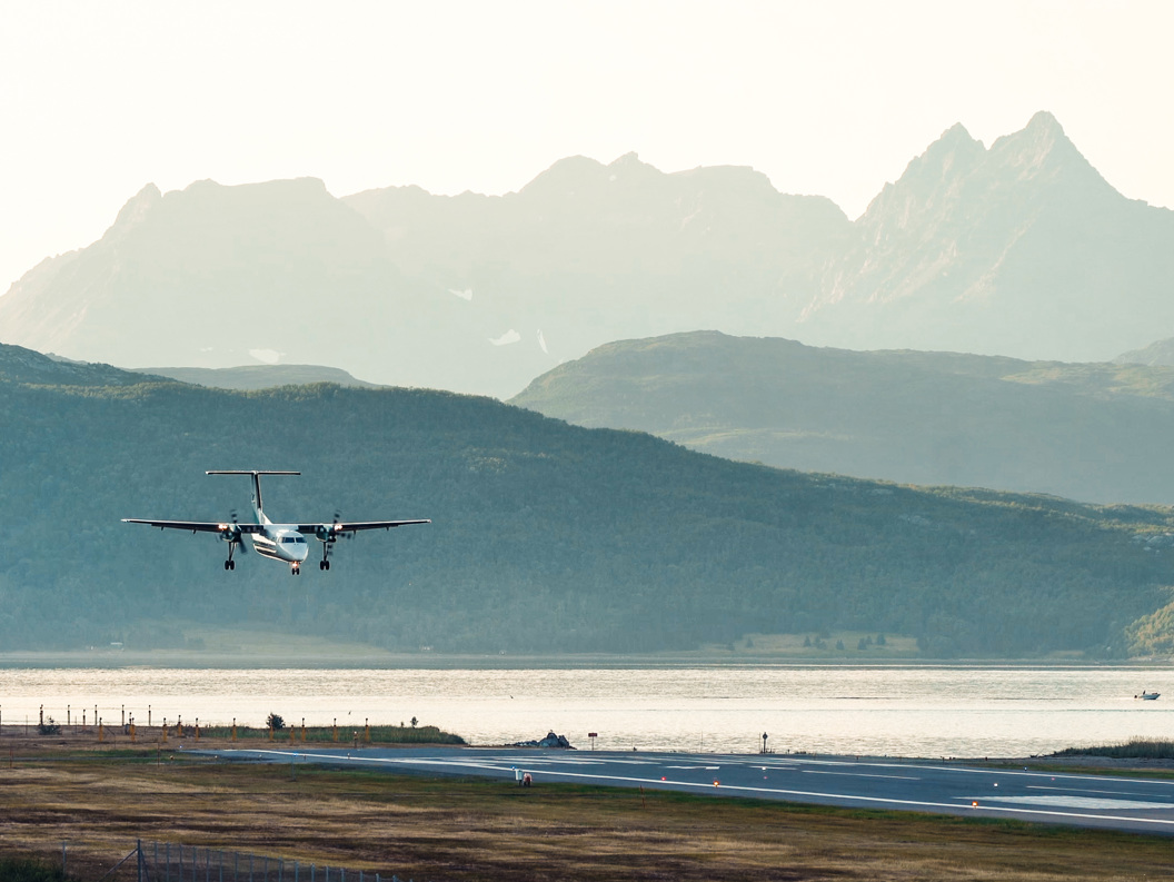 Fly lander på Sørkjosen flyplass med fjell i bakgrunnen.
