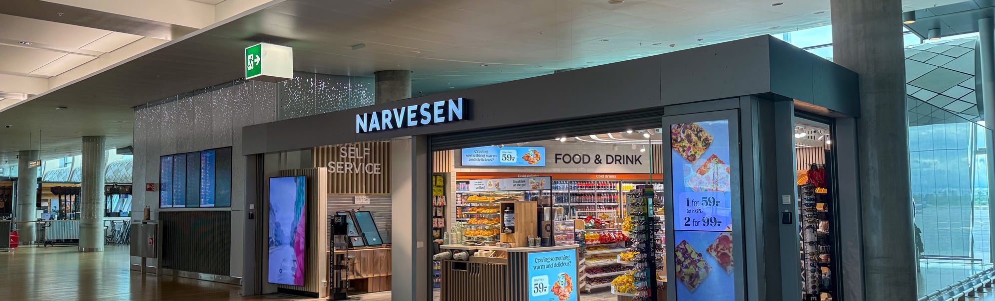 Narvesen-kiosk med food & drink i en moderne flyplassterminal med tomt gulv og selvbetjening