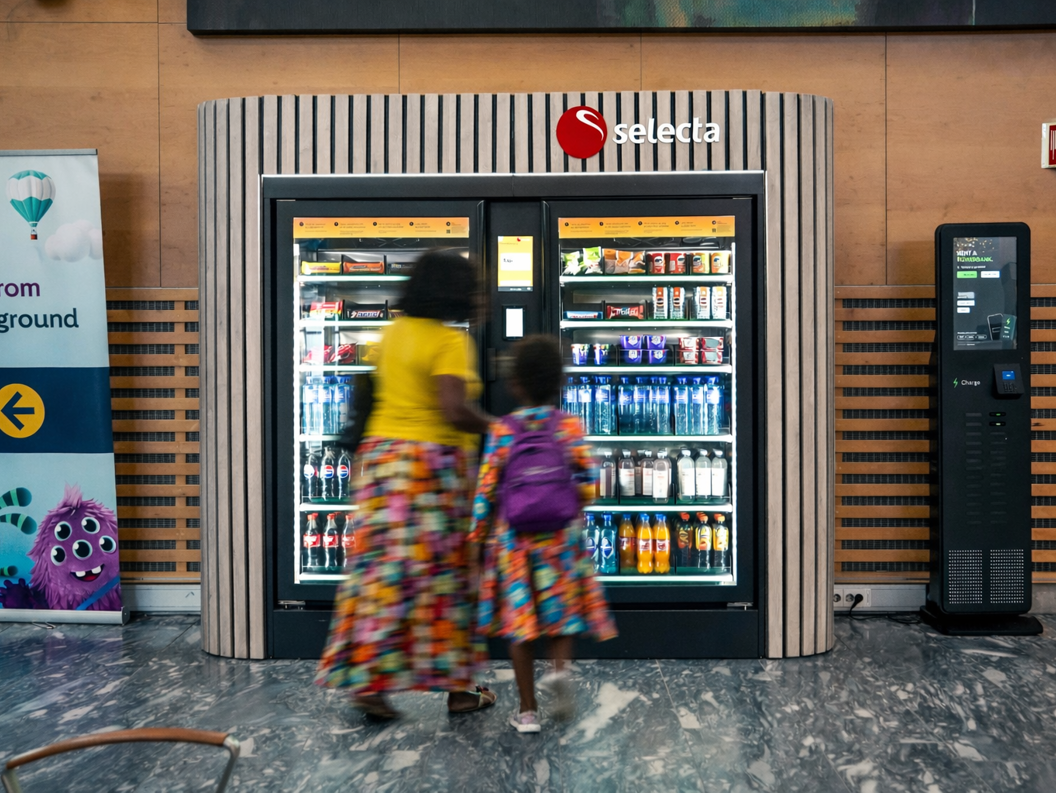 Automat fylt med ulike snacks og sjokoladebarer, inkludert populære merker, med opplyst utvalgspanel
