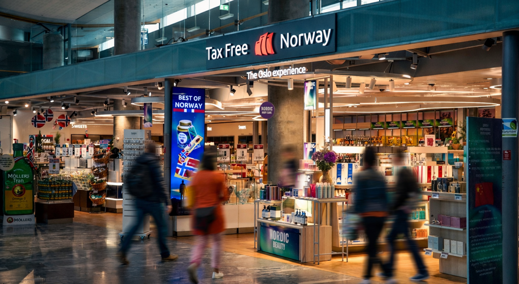 Woman shopping for sunglasses in a store, trying on a pair and smiling, wearing a black leather jacket