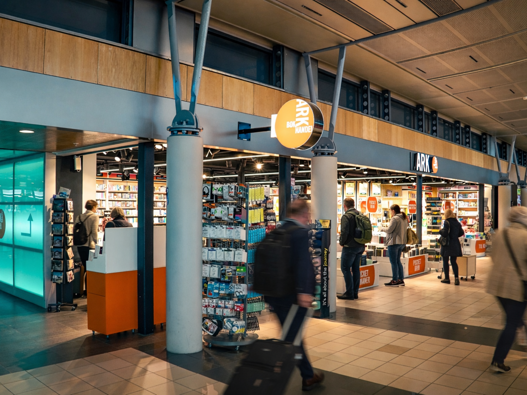 Kvinne blar gjennom fargerike barnebøker på en hylle i en bokhandel